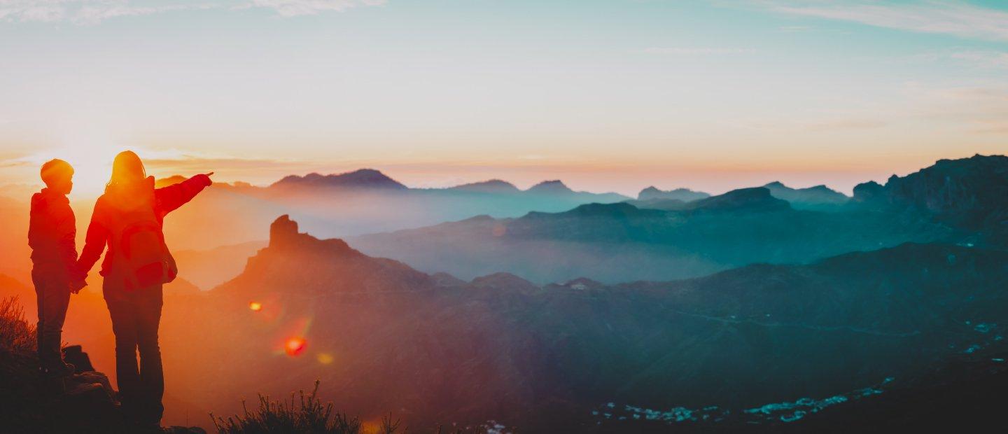 两个人站在山顶上俯瞰群山.