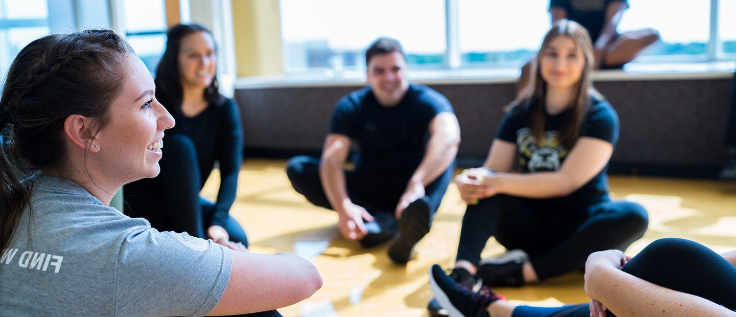 People seated in a group exercise studio.